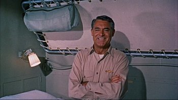 Movie still from “Operation Petticoat” (1959), directed by Blake Edwards – An older man standing with his arms crossed; Medium shot, Low angle