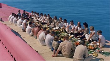 Movie still from “Operation Petticoat” (1959), directed by Blake Edwards – A group of people sitting around a table eating; Wide shot, High angle
