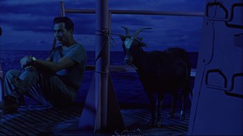 Movie still from “Operation Petticoat” (1959), directed by Blake Edwards – A goat standing next to a man on a pier; Wide shot, High angle