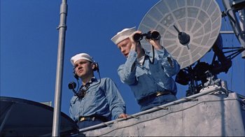 Movie still from “Operation Petticoat” (1959), directed by Blake Edwards – Two men in blue shirts and white hats are on a boat; Medium shot, Low angle