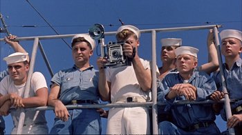 Movie still from “Operation Petticoat” (1959), directed by Blake Edwards – A group of men standing next to each other on a boat; Medium shot, Low angle