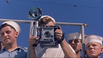 Movie still from “Operation Petticoat” (1959), directed by Blake Edwards – A man taking a picture of another man holding a camera; Close Up shot, Low angle