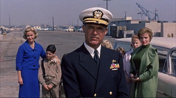 Movie still from “Operation Petticoat” (1959), directed by Blake Edwards – A man in a uniform standing in front of a group of people; Medium shot, Low angle