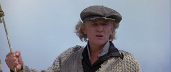 Movie still from “Orca” (1977), directed by Michael Anderson – A man wearing a hat and a sweater; Close Up shot, Low angle