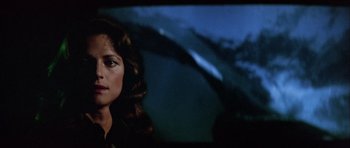 Movie still from “Orca” (1977), directed by Michael Anderson – A person in front of a projector screen; Close Up shot, Over the shoulder angle