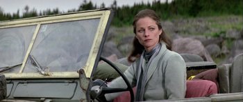 Movie still from “Orca” (1977), directed by Michael Anderson – A woman sitting in the driver's seat of an old car; Close Up shot, Low angle