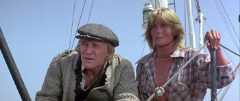 Movie still from “Orca” (1977), directed by Michael Anderson – A man and a woman sitting on a boat in the water; Close Up shot, Low angle