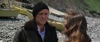 Movie still from “Orca” (1977), directed by Michael Anderson – A man and a woman talking on the beach; Close Up shot, Over the shoulder angle