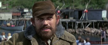 Movie still from “Orca” (1977), directed by Michael Anderson – A man with a beard wearing a hat and jacket; Close Up shot, Low angle