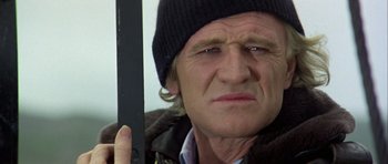 Movie still from “Orca” (1977), directed by Michael Anderson – A person holding a knife; Close Up shot, Low angle