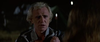 Movie still from “Orca” (1977), directed by Michael Anderson – An older man is looking at a woman; Close Up shot, Over the shoulder angle