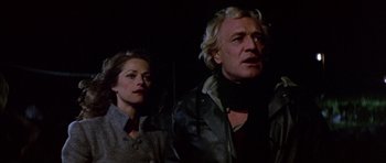 Movie still from “Orca” (1977), directed by Michael Anderson – A man and a woman standing next to each other in the dark; Close Up shot, Low angle