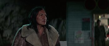 Movie still from “Orca” (1977), directed by Michael Anderson – An older native american man wearing a blanket; Close Up shot, Low angle