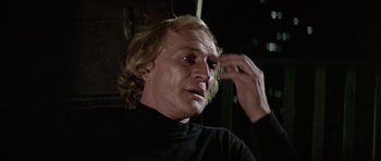 Movie still from “Orca” (1977), directed by Michael Anderson – A person wearing a black shirt; Close Up shot, Over the shoulder angle