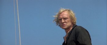 Movie still from “Orca” (1977), directed by Michael Anderson – A person with long blonde hair; Close Up shot, Low angle