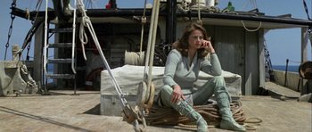 Movie still from “Orca” (1977), directed by Michael Anderson – A woman sitting on the ground next to ropes; Wide shot, Low angle