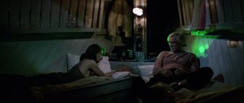 Movie still from “Orca” (1977), directed by Michael Anderson – A man and a woman sitting on a bed looking at a laptop; Medium shot, High angle