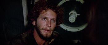 Movie still from “Orca” (1977), directed by Michael Anderson – A person with curly red hair; Close Up shot, Low angle