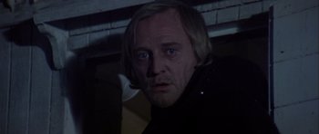 Movie still from “Orca” (1977), directed by Michael Anderson – A person wearing a black jacket; Close Up shot, Low angle