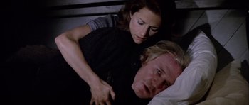 Movie still from “Orca” (1977), directed by Michael Anderson – A man and a woman laying in bed together; Close Up shot, High angle