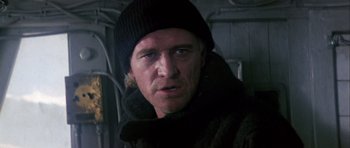 Movie still from “Orca” (1977), directed by Michael Anderson – A person wearing a hat and a jacket; Close Up shot, Low angle