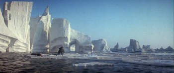 Movie still from “Orca” (1977), directed by Michael Anderson – A man riding a horse on top of a snow covered field; Extreme Wide shot, High angle