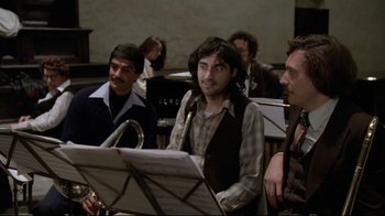 Movie still from “Orchestra Rehearsal” (1978), directed by Federico Fellini – A group of people sitting around a room; Medium shot, High angle