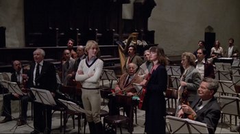 Movie still from “Orchestra Rehearsal” (1978), directed by Federico Fellini – A group of people sitting in a room with musical instruments; Wide shot, High angle