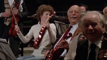 Movie still from “Orchestra Rehearsal” (1978), directed by Federico Fellini – An older man and a younger woman are playing a musical instrument together; Medium shot, Low angle