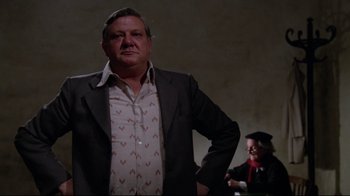 Movie still from “Orchestra Rehearsal” (1978), directed by Federico Fellini – A man in a suit and tie standing next to another man in a suit; Medium shot, Low angle