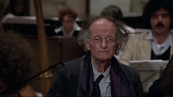 Movie still from “Orchestra Rehearsal” (1978), directed by Federico Fellini – An old man with a beard and a tie around his neck; Close Up shot, Low angle