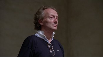Movie still from “Orchestra Rehearsal” (1978), directed by Federico Fellini – A man in a blue shirt is looking to the side; Close Up shot, Low angle