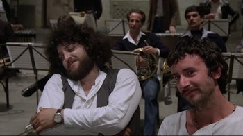 Movie still from “Orchestra Rehearsal” (1978), directed by Federico Fellini – A group of men sitting in front of each other; Medium shot, Low angle