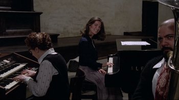 Movie still from “Orchestra Rehearsal” (1978), directed by Federico Fellini – A woman sitting in front of a grand piano; Medium shot, High angle