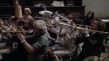 Movie still from “Orchestra Rehearsal” (1978), directed by Federico Fellini – A group of people sitting in a room playing musical instruments; Medium shot, High angle