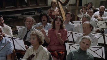 Movie still from “Orchestra Rehearsal” (1978), directed by Federico Fellini – A group of people sitting in a room with musical instruments; Medium shot, High angle