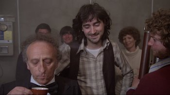 Movie still from “Orchestra Rehearsal” (1978), directed by Federico Fellini – A group of people standing in a room; Medium shot, Over the shoulder angle