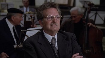Movie still from “Orchestra Rehearsal” (1978), directed by Federico Fellini – An older man in a suit and tie; Close Up shot, Low angle