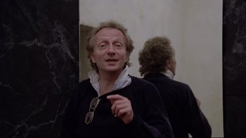 Movie still from “Orchestra Rehearsal” (1978), directed by Federico Fellini – A man in a black sweater and sunglasses; Close Up shot, Over the shoulder angle