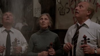 Movie still from “Orchestra Rehearsal” (1978), directed by Federico Fellini – A woman in a green sweater holding a pair of chopsticks; Medium shot, Low angle