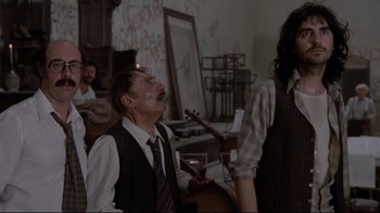 Movie still from “Orchestra Rehearsal” (1978), directed by Federico Fellini – A group of people standing in a room; Medium shot, Low angle