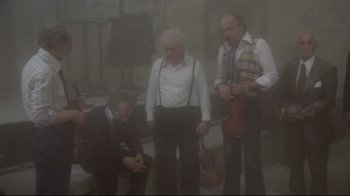 Movie still from “Orchestra Rehearsal” (1978), directed by Federico Fellini – A group of men standing next to each other in the fog; Wide shot, High angle