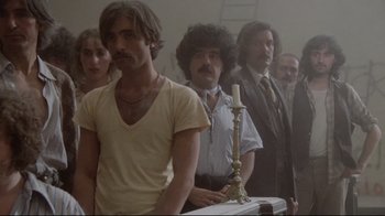 Movie still from “Orchestra Rehearsal” (1978), directed by Federico Fellini – A group of men standing next to each other in a room; Medium shot, Low angle