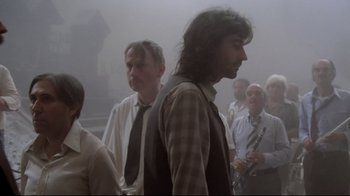 Movie still from “Orchestra Rehearsal” (1978), directed by Federico Fellini – A group of men standing in a foggy room; Medium shot, Low angle