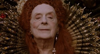 Movie still from “Orlando” (1992), directed by Sally Potter – An older woman with red hair and a large headpiece; Close Up shot, Over the shoulder angle