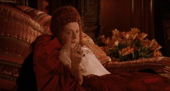 Movie still from “Orlando” (1992), directed by Sally Potter – An older woman sitting on a couch holding a piece of paper; Medium shot, Over the shoulder angle