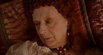 Movie still from “Orlando” (1992), directed by Sally Potter – An older woman with red hair wearing a necklace; Close Up shot, High angle