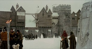 Movie still from “Orlando” (1992), directed by Sally Potter – A painting of a medieval castle with people standing around it; Extreme Wide shot, Low angle