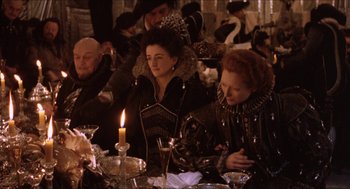 Movie still from “Orlando” (1992), directed by Sally Potter – A group of people sitting around a table with a candle; Medium shot, High angle