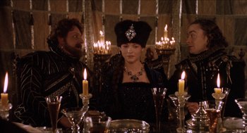 Movie still from “Orlando” (1992), directed by Sally Potter – A group of people sitting around a table with lit candles; Medium shot, Over the shoulder angle